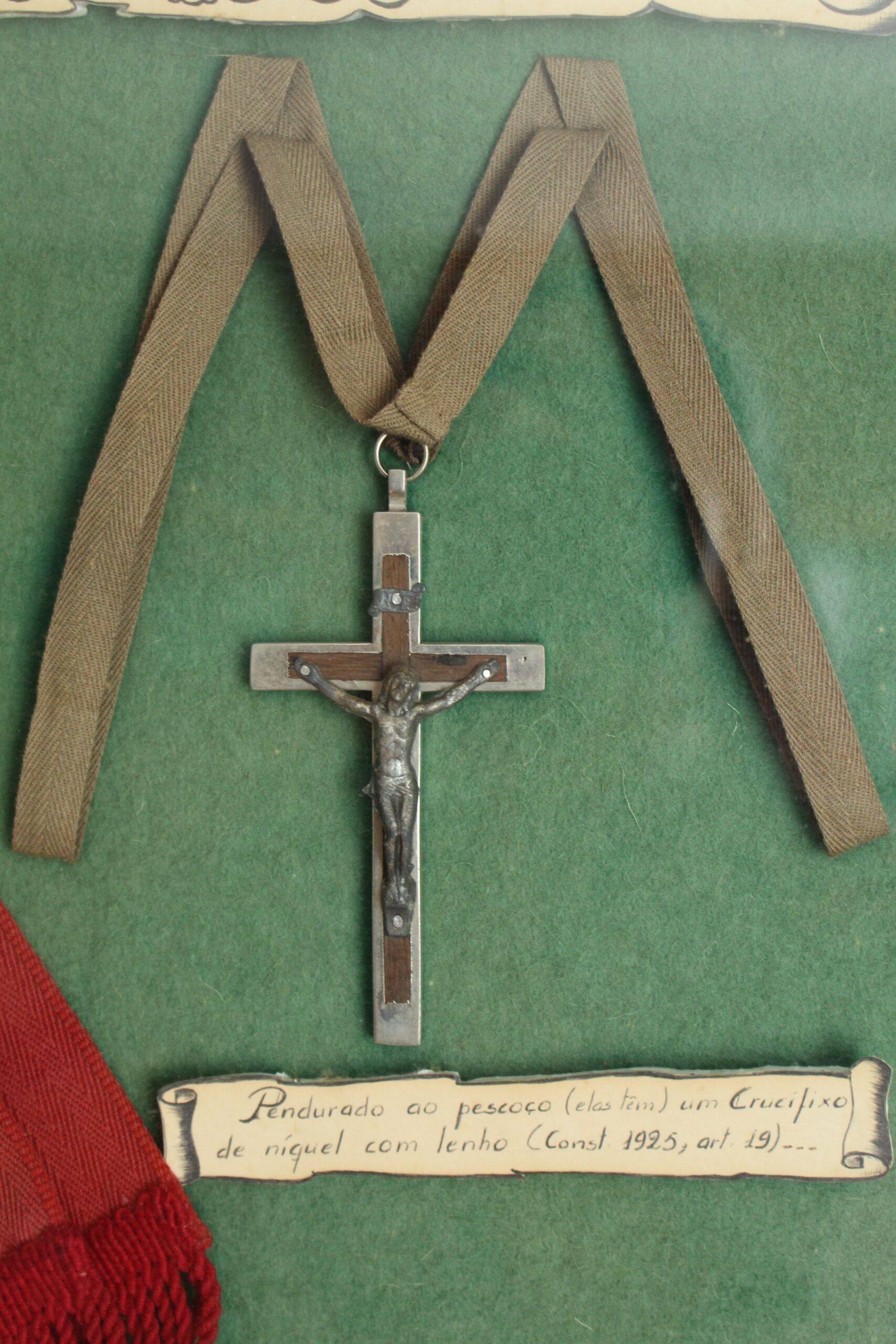 Crucifixo pendurado no pescoço, feito de níquel e lenho (Constituições 1925, artigo 19)